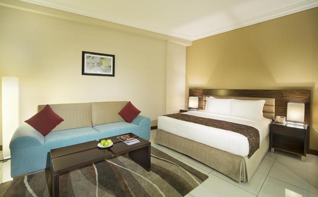 a hotel room with a bed and a couch at Gateway Hotel in Dubai