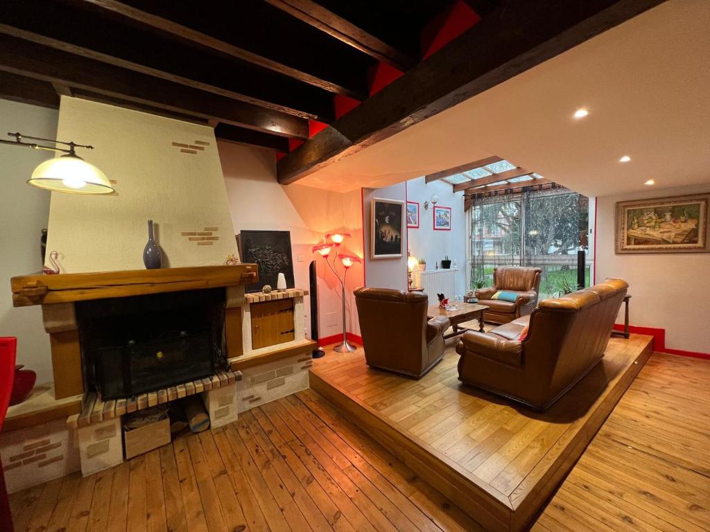 ein Wohnzimmer mit 2 Stühlen und einem Kamin in der Unterkunft Appartement privé in Lourdes
