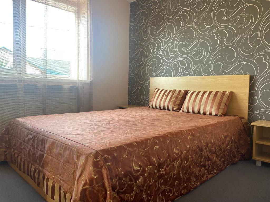 a bedroom with a bed with a patterned wall at B Apartment in Vilnius in Vilnius
