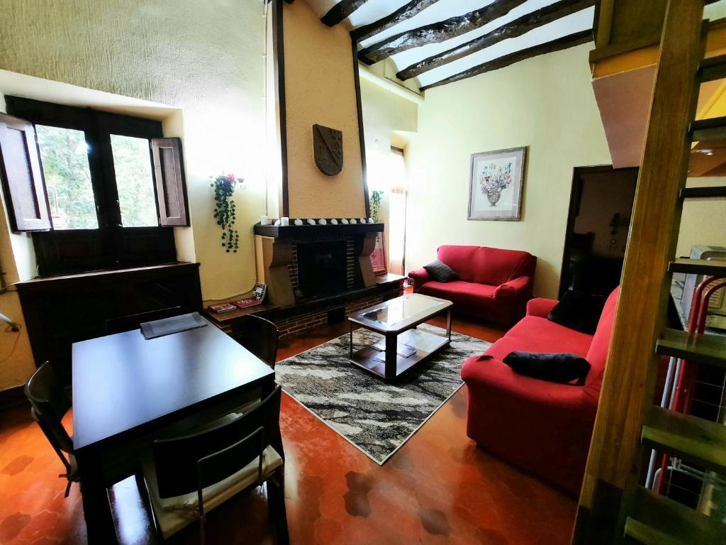 a living room with a red couch and a fireplace at Apartamento medieval en el Camino De Santiago in Estella