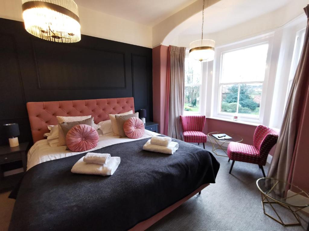 a bedroom with a large bed with two pillows on it at Blakeney House in Blakeney
