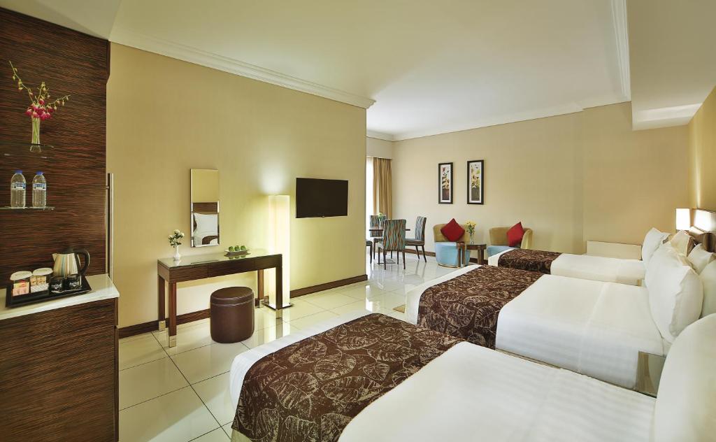 a hotel room with two beds and a desk at Gateway Hotel in Dubai