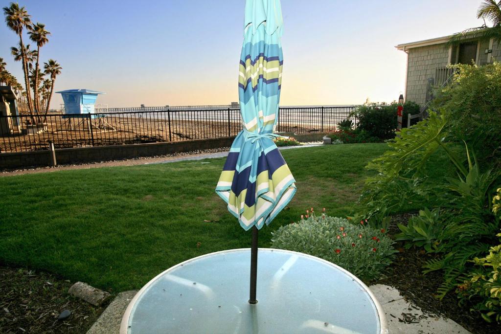 un paraguas azul y amarillo sobre una mesa en un patio en D11 - Beachfront Luxury, en Oceanside