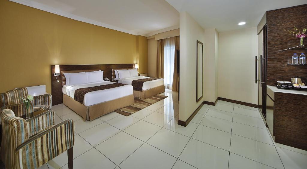 a hotel room with two beds and a bathroom at Gateway Hotel in Dubai