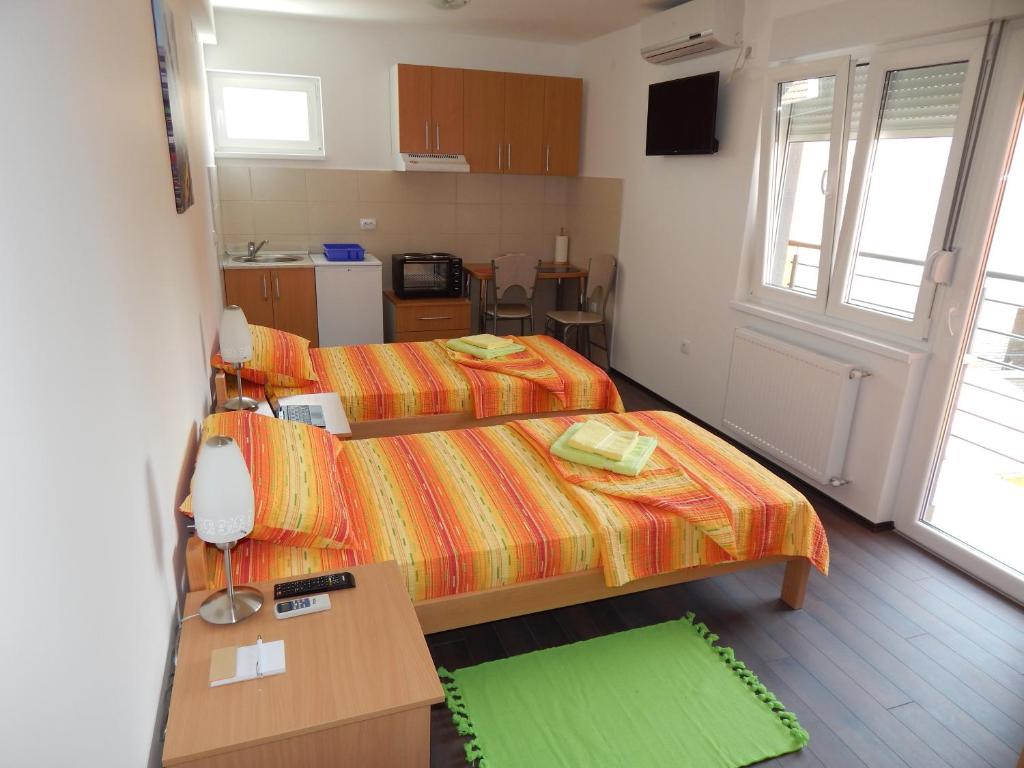 a small room with two beds and a kitchen at Apartments Center KG in Kragujevac