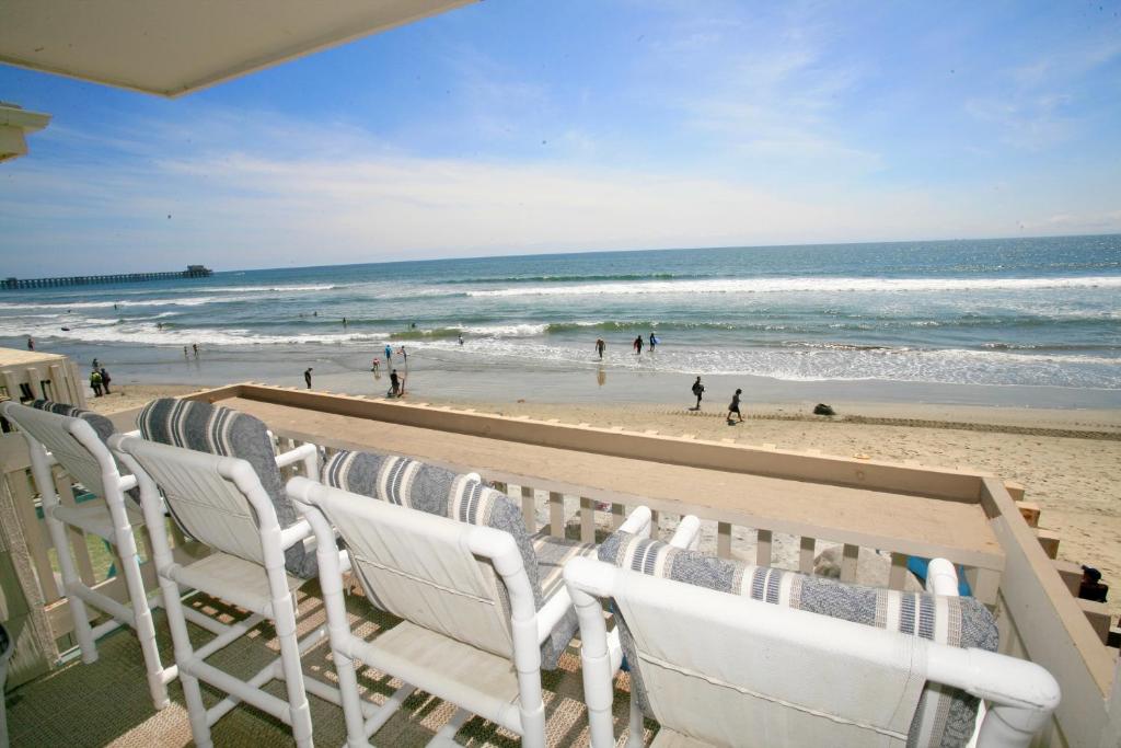 a row of chairs sitting on the beach at D20 - Beachfront Delight in Oceanside