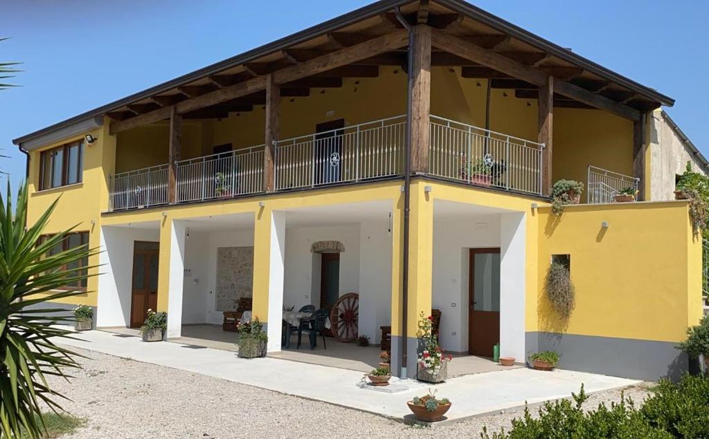 uma casa amarela com uma varanda em cima em Agriturismo B&B Dal Professore em Sicignano degli Alburni