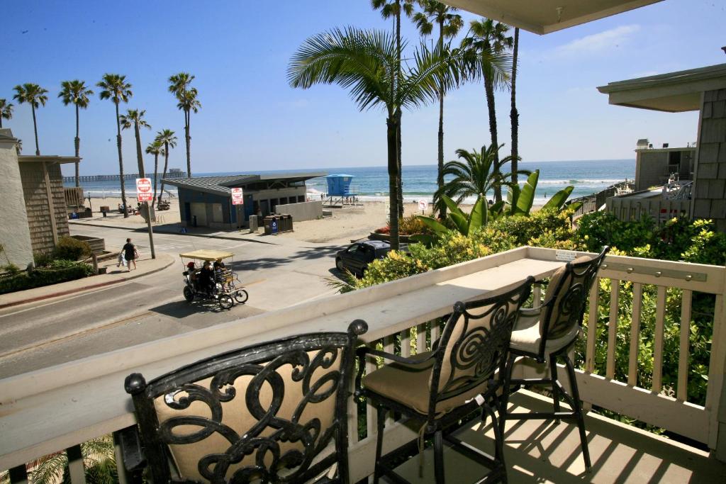 een balkon met een tafel en stoelen en het strand bij D2 - Breakwater Bungalow in Oceanside