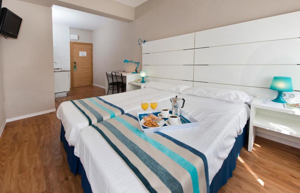 pokój hotelowy z łóżkiem z tacą z jedzeniem w obiekcie Estudios Aránzazu w mieście Santander