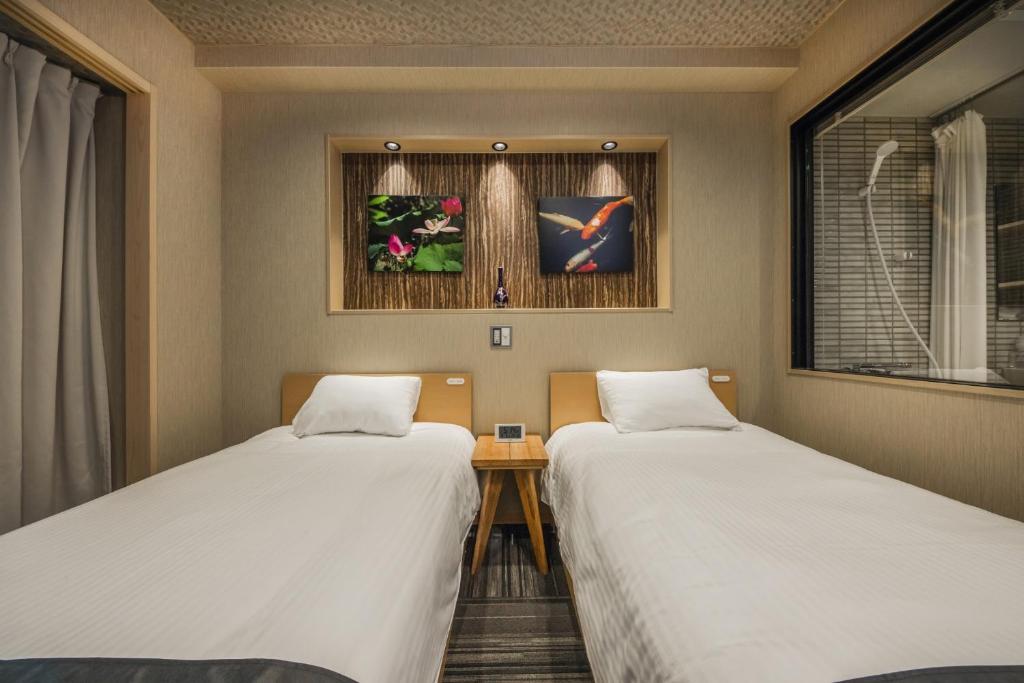 a room with two beds and a table and a window at Shiki Suites - Vacation STAY 22189v in Kyoto