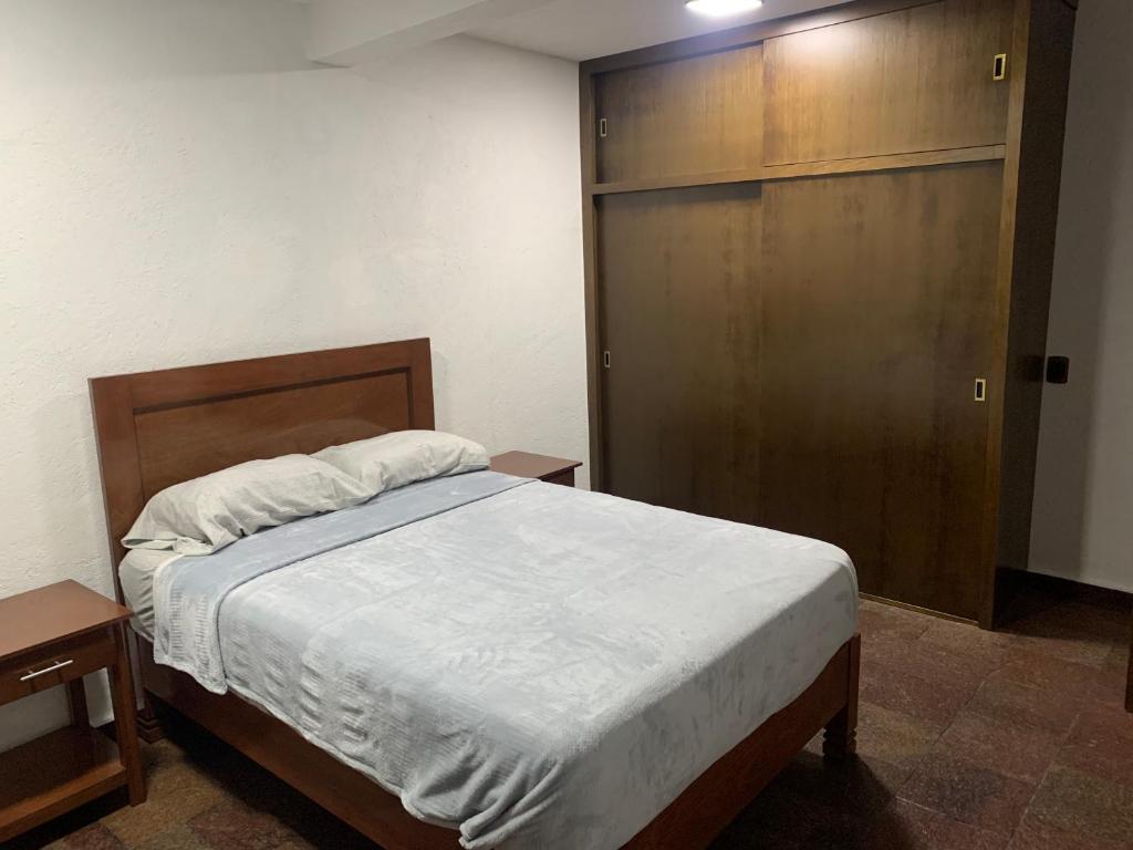 um quarto com uma cama e uma porta de madeira em Depametepec55 em Toluca