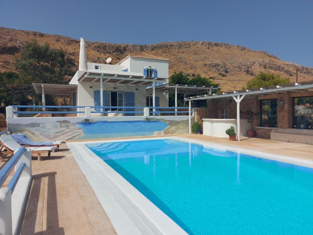 a villa with a swimming pool and a house at Simos suites in Elafonisos