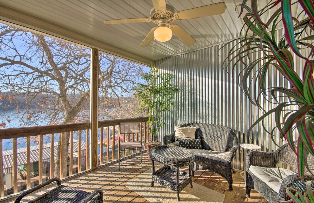 a screened porch with chairs and a ceiling fan at Waterfront Townhome with Private Dock and Lake Views in Lake Ozark