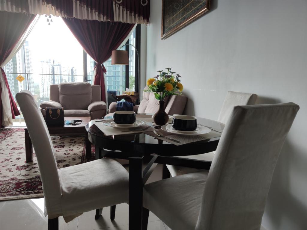 Kumkum Homestay 3 bedroom suite في نوساجايا: غرفة طعام مع طاولة سوداء وكراسي