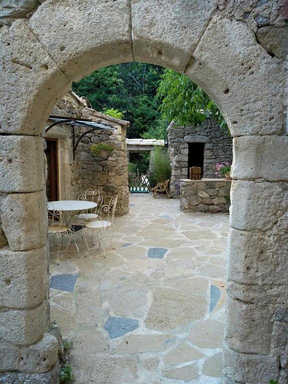 une arche dans un bâtiment en pierre avec une terrasse dans l'établissement Les MIMOSAS Gîte du Mas Haut, à Saint-Jean-du-Gard