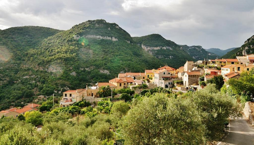 a village on a hill with mountains in the background at Agriturismo Barilaro in Finale Ligure