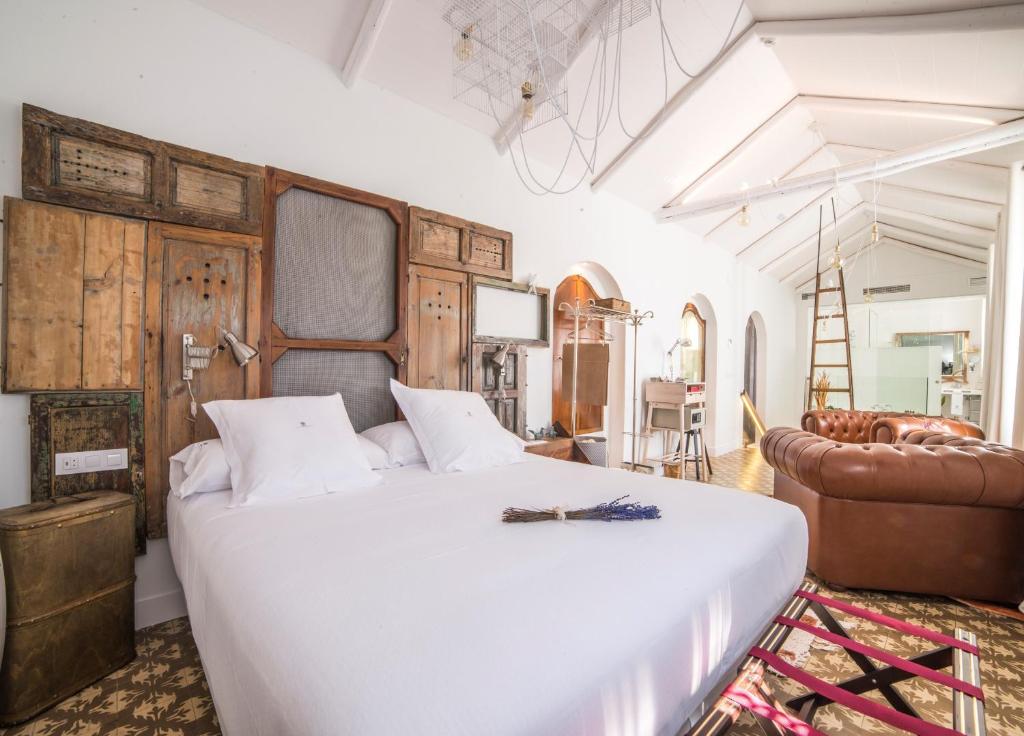 a bedroom with a large white bed and a couch at Hotel Madinat in Córdoba