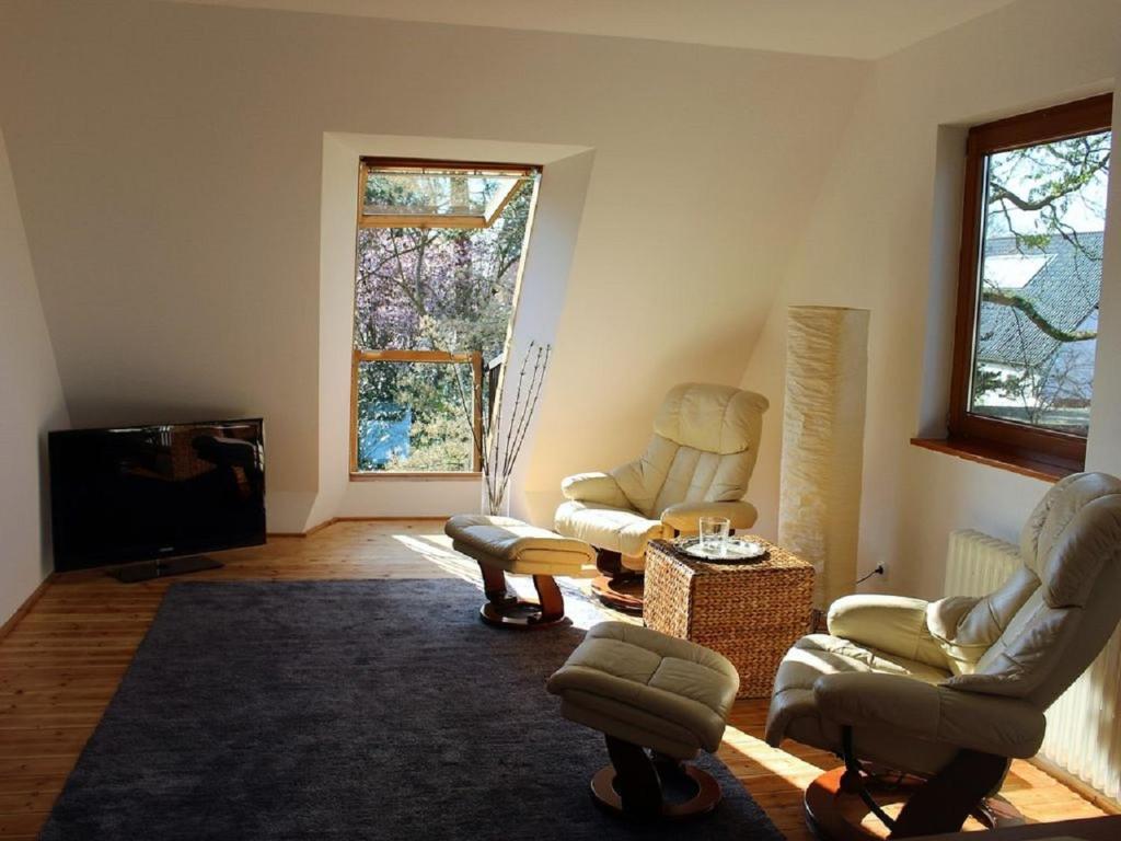 uma sala de estar com duas cadeiras e uma televisão em Top Appartement 1 in Rosengarten/Hamburg em Rosengarten