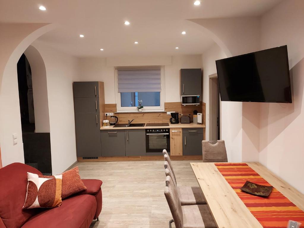 a living room with a red couch and a kitchen at Ferienwohnung Popp in Erzhausen