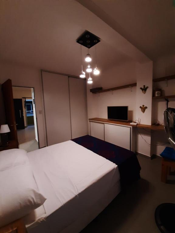um quarto com uma grande cama branca e uma secretária em Via Almafuerte em Concepción del Uruguay