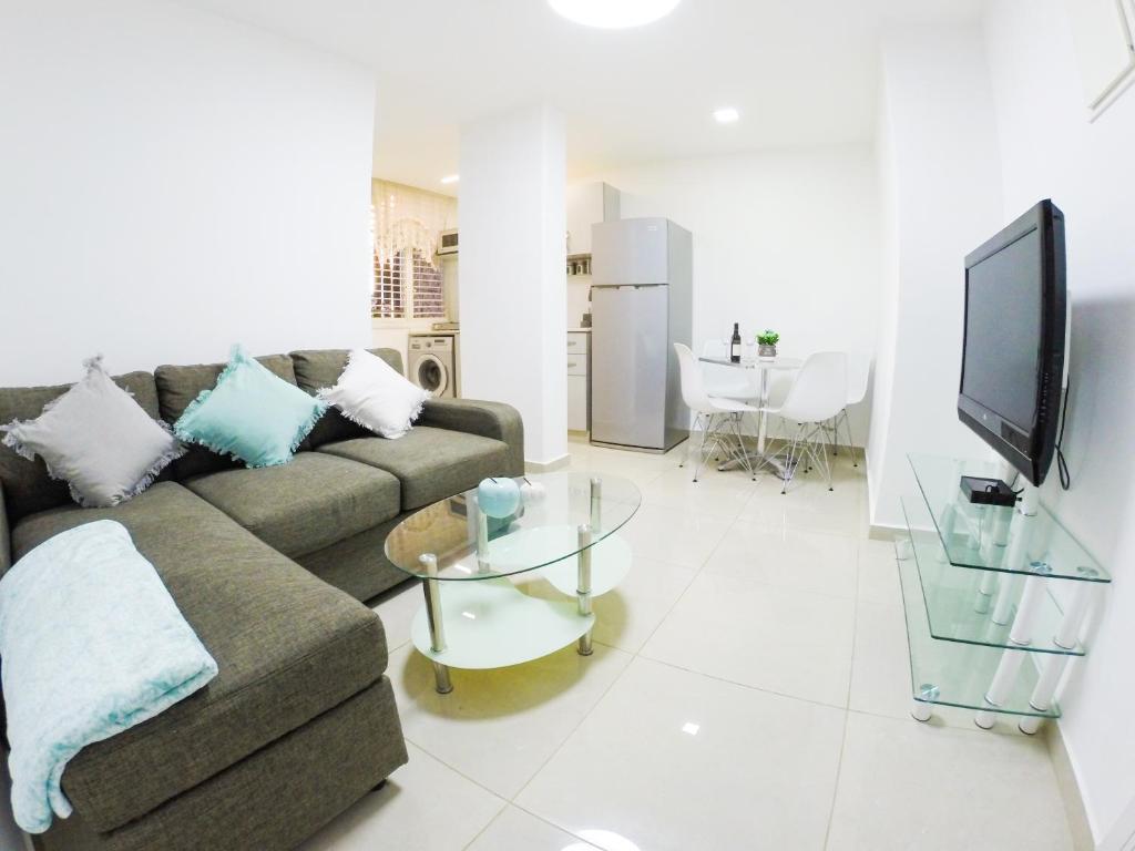 a living room with a couch and a tv at Great Location Fully Equipped in Eilat