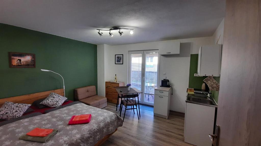 Cet appartement comprend une chambre avec un lit et une cuisine avec une table. dans l'établissement BIKE apartments 1, à Hodruša