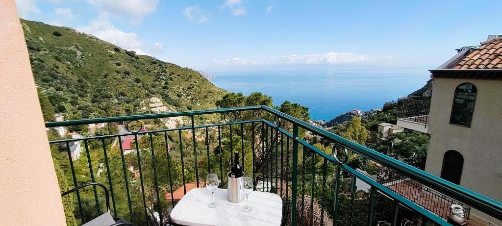 balcone con tavolo e bottiglia di vino di Casa Pasitea a Taormina