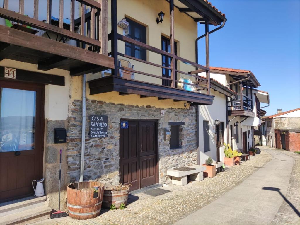 a building with a wooden door and a balcony at Falagueira in Monforte de Lemos