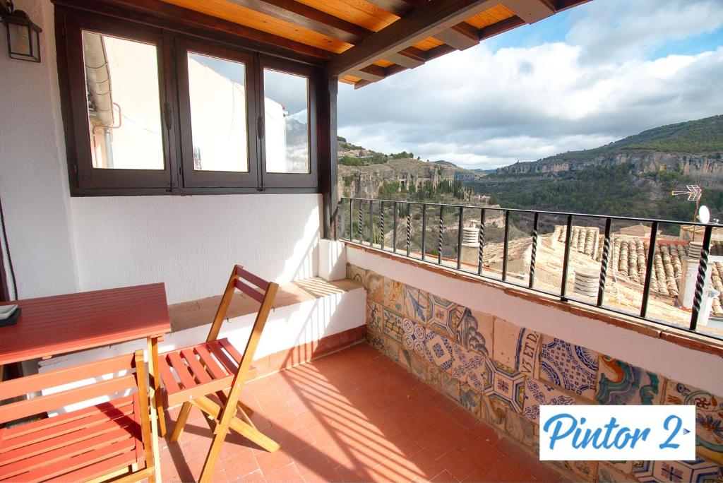a balcony with a bench and a view of the mountains at Cuencaloft el mirador del pintor in Cuenca
