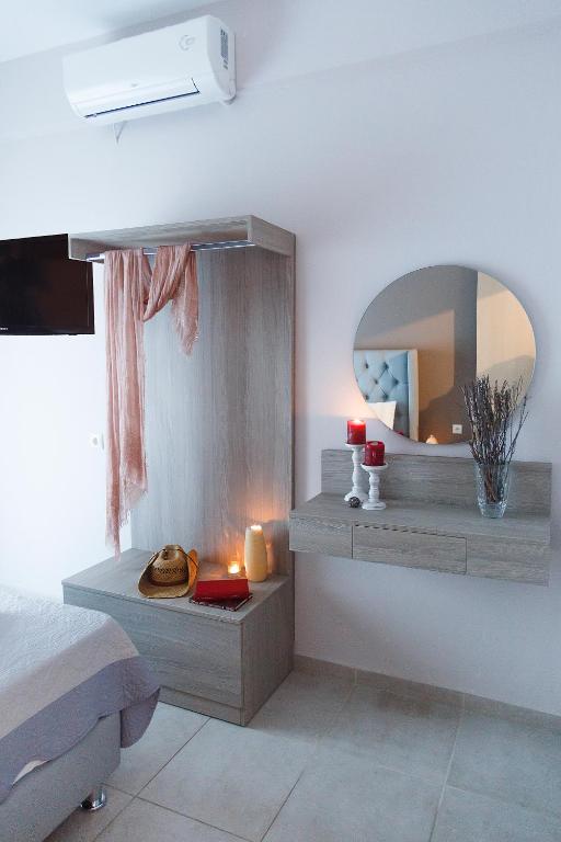 a bedroom with a mirror on the wall and a bed at Sueño Luxury Apartments in Polychrono