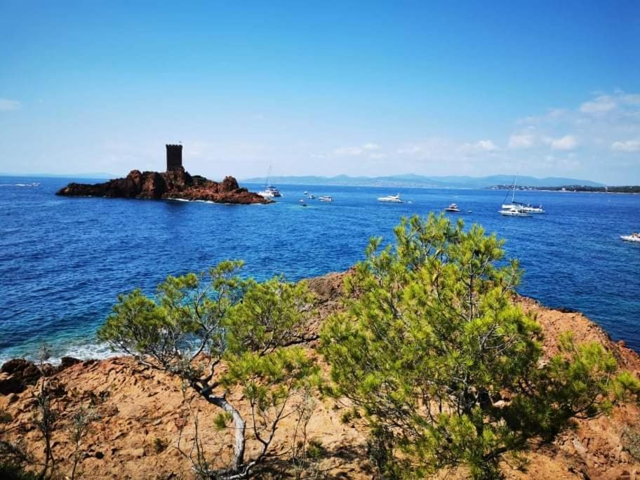 une île dans l'océan avec un phare sur elle dans l'établissement Charmant Mobil home avec Vue mer exceptionnelle, à Saint-Raphaël