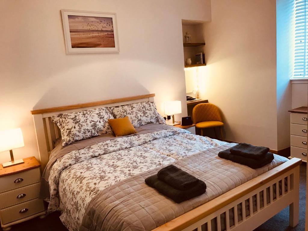 a bedroom with a bed with two towels on it at Logan Home in Stornoway