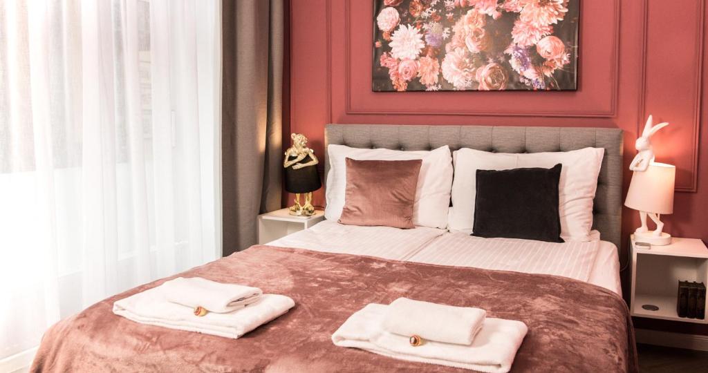 - une chambre avec un grand lit et 2 serviettes dans l'établissement Nikolai Homes, à Vienne