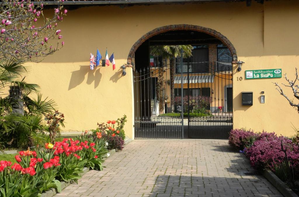 una entrada a un edificio con una puerta y flores en Bed&Breakfast La Siepe, en Pinerolo