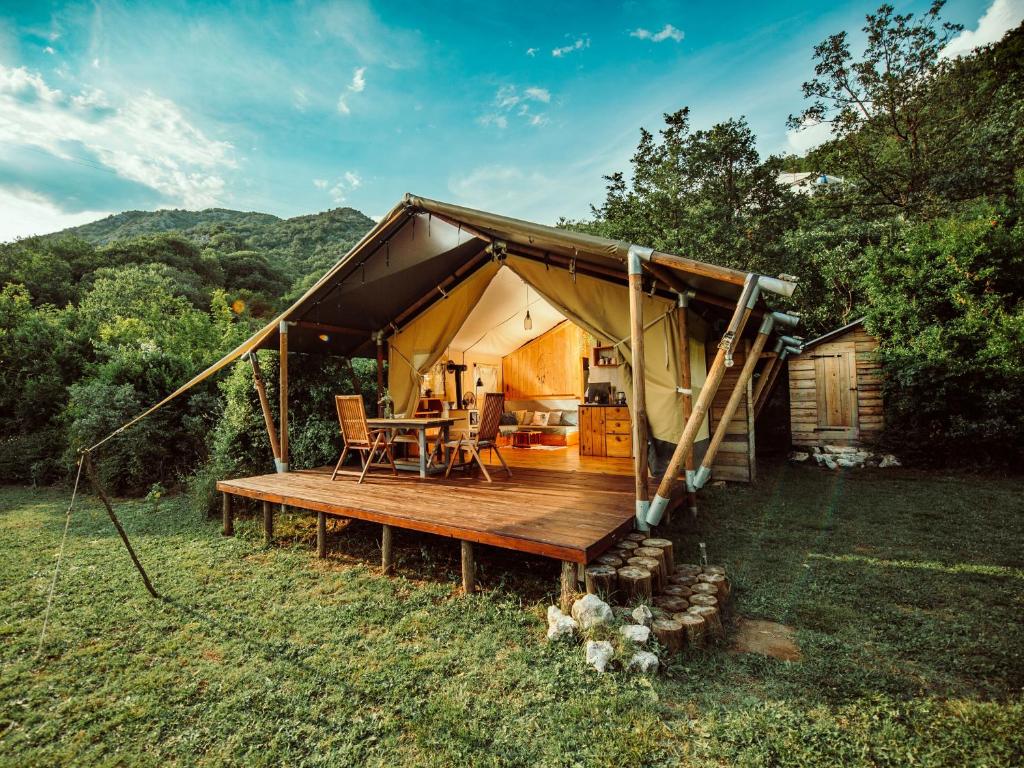 a yurt with a wooden deck in the grass at Hoopoe Glamping in Virpazar