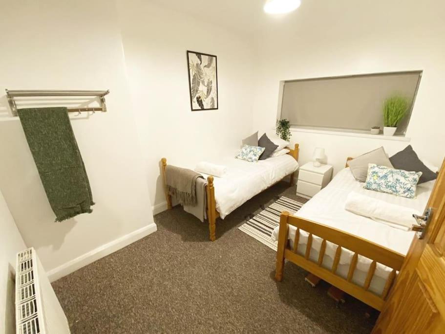 a living room with a bed and a couch at Team House -Walsall, M6 J7 - 11 beds, Nr B-Ham, Free Parking in Bescot