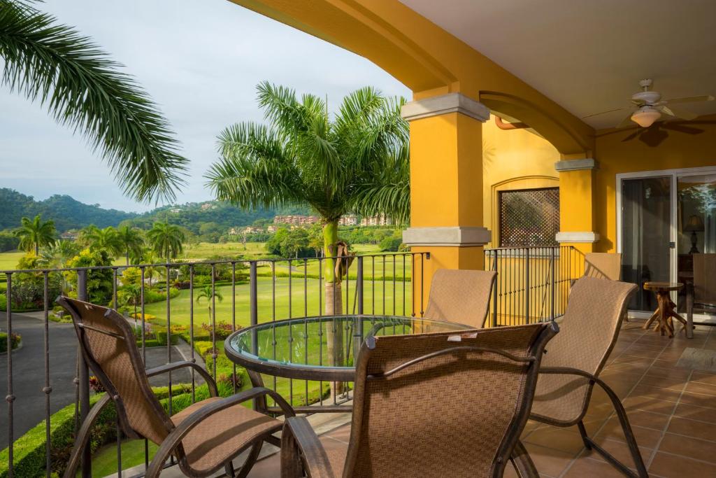 Un patio con sillas y una mesa en el balcón. en Los Suenos Resort Del Mar 5F golf views by Stay in CR en Herradura