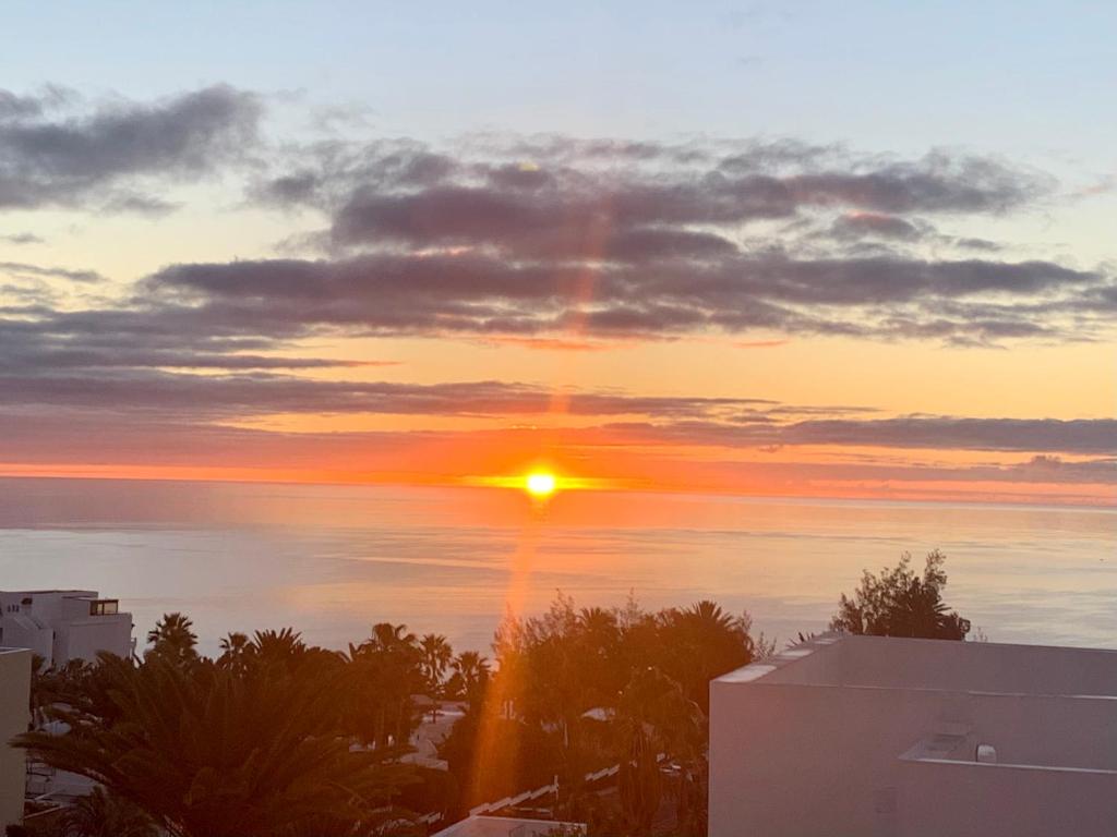 een zonsondergang boven de oceaan met de zon in de lucht bij SUNRISE ESQUINZO, paraíso de sol & playa & paz in Playa Jandia