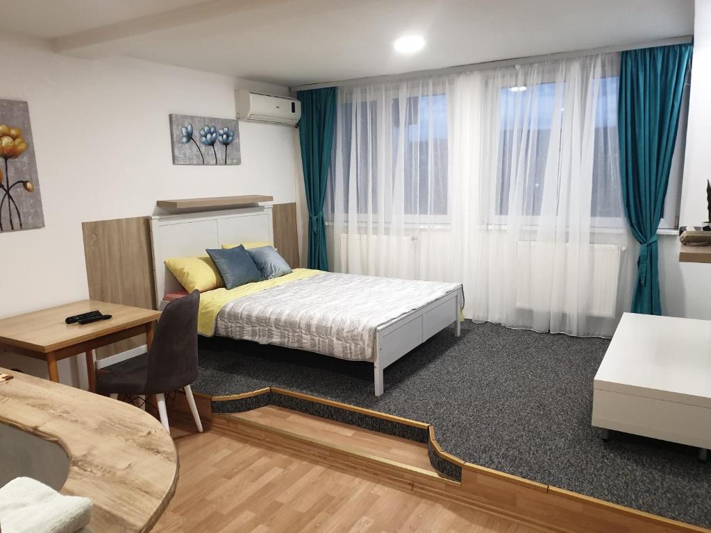 Schlafzimmer mit einem Bett, einem Tisch und einem Schreibtisch in der Unterkunft City center apartment 2 in Niš