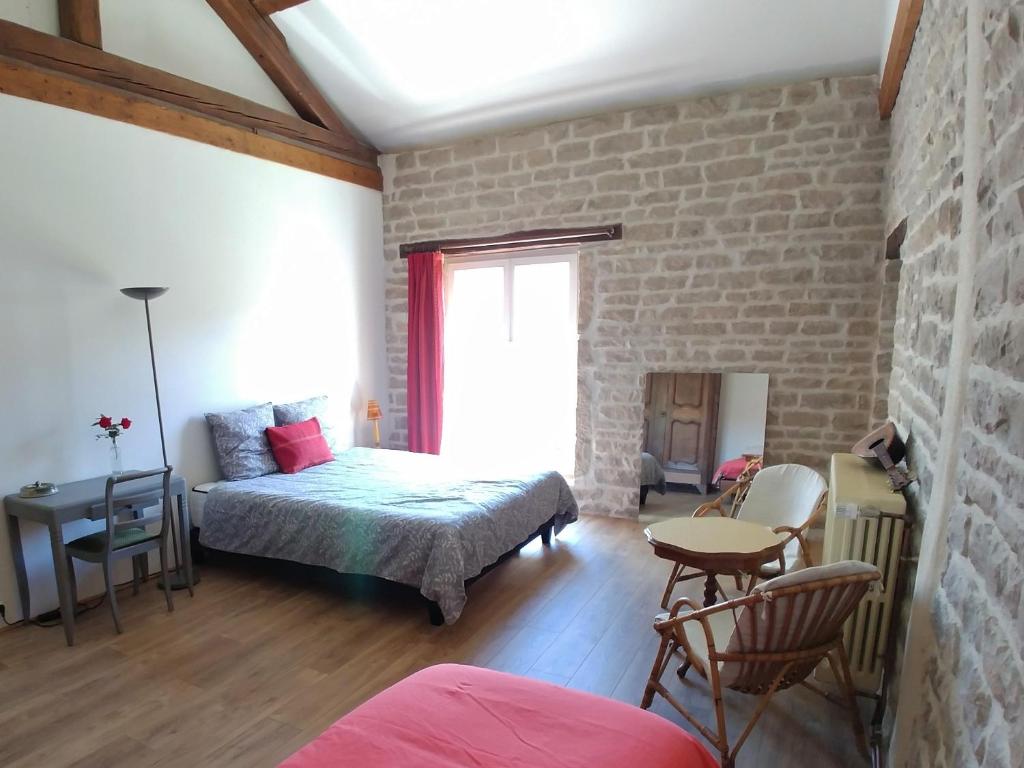 a bedroom with a bed and a brick wall at 2 chambres privées au calme à la Maison des Bambous in Dijon