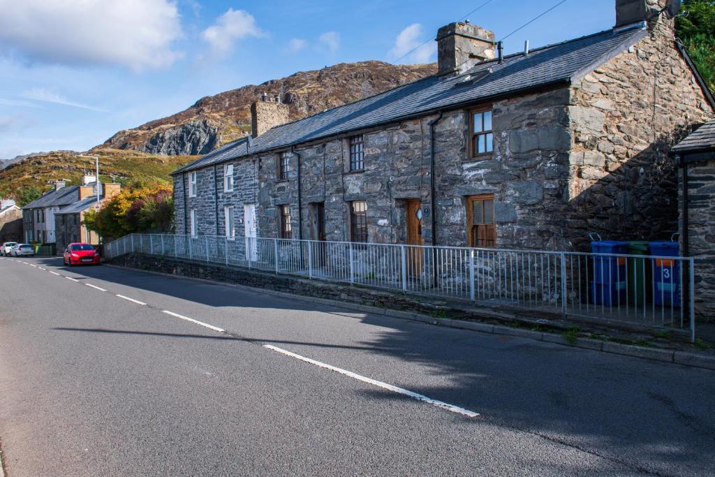 a stone building on the side of a road at Homely cottage with garden and mountain-view in Blaenau-Ffestiniog