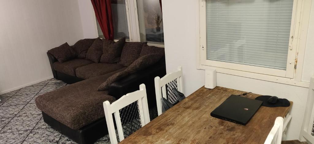 een woonkamer met een bank en een tafel bij 55 neliöinen Tilava RivitaloKaksio, 1-4hlö, Täydellinen keittiö, Uudet kodinkoneet, sauna, tv, netflix, wifi in Seinäjoki
