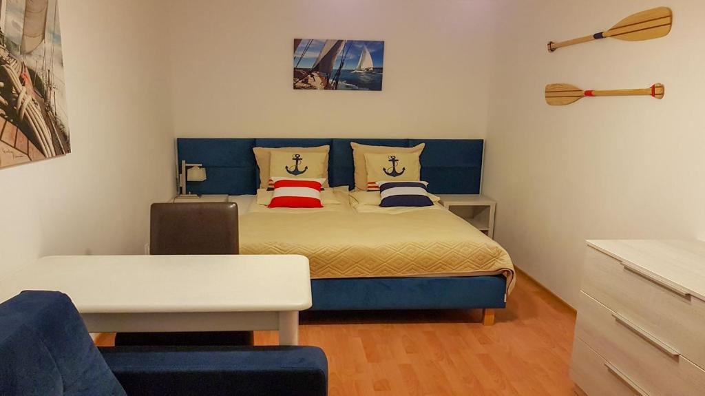 Schlafzimmer mit einem Bett mit blauem Kopfteil in der Unterkunft Apartamenty Agat i Jantar in Świnoujście