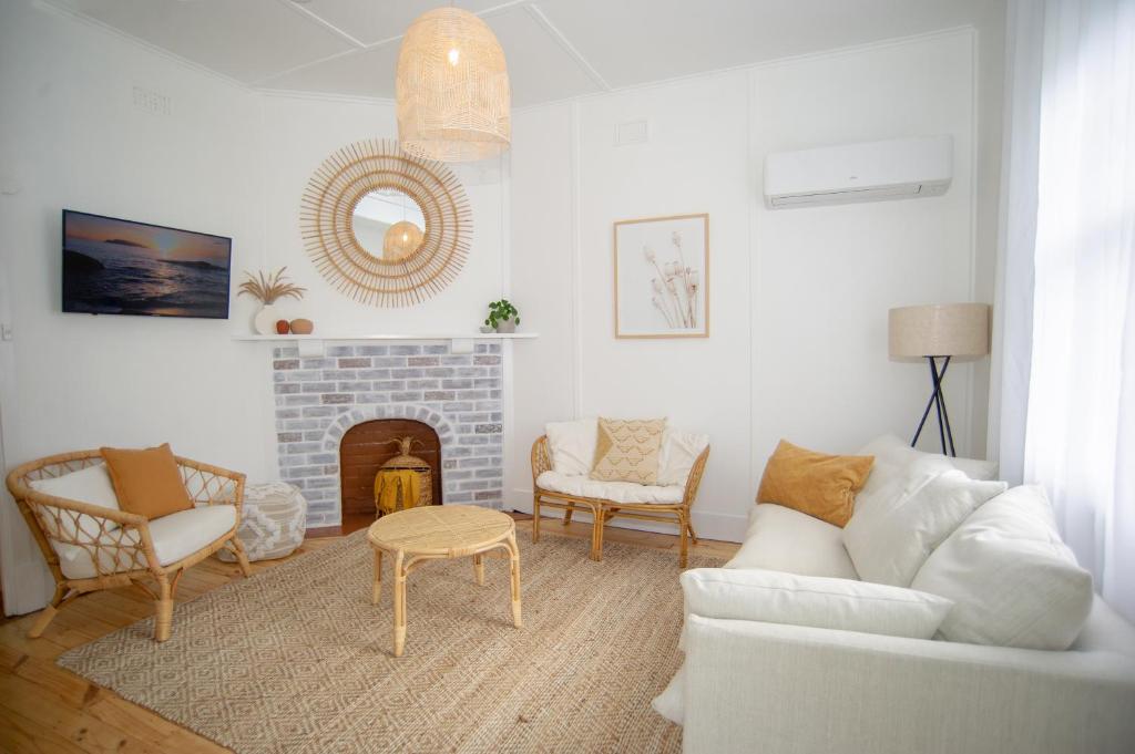 a living room with a white couch and a fireplace at Willow McLaren Vale in McLaren Vale