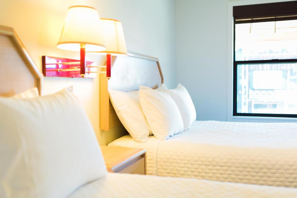 una habitación de hotel con 2 camas y una lámpara en Two Sunsets Hotel en Panguitch