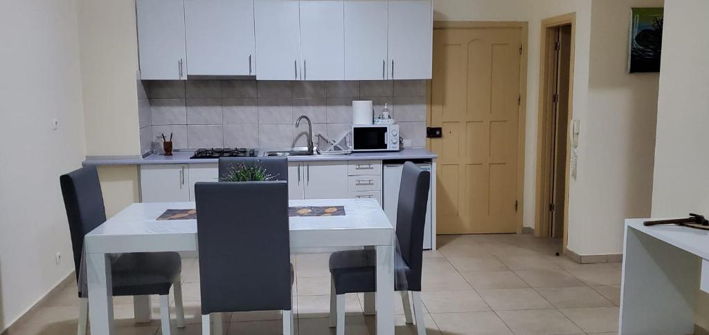 una cocina con mesa blanca y sillas. en Apartamento Teixeira, en Espargos