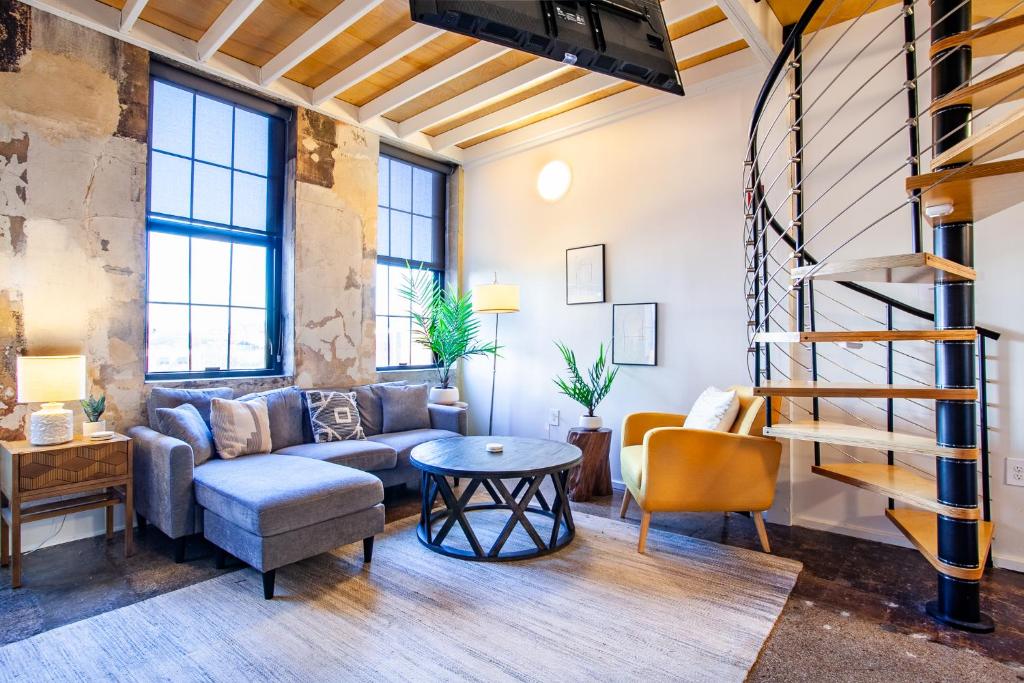 a living room with a couch and a table at Sterchi Lofts Getaway - Downtown Knoxville in Knoxville