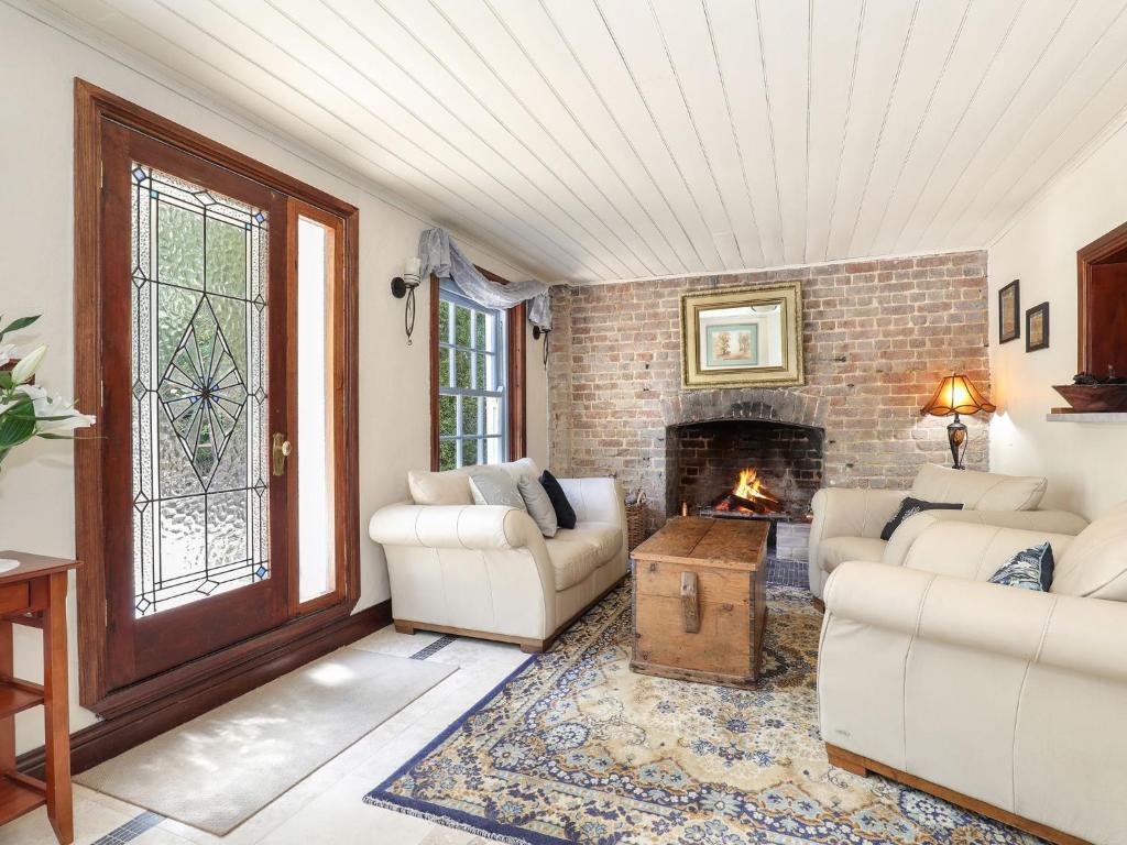 The Coach House في جبل فيكتوريا: غرفة معيشة مع كنبتين ومدفأة