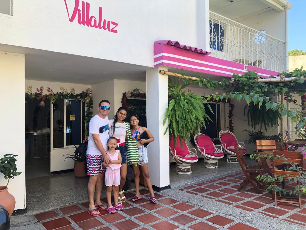 a family posing in front of a building at Casa Hospedaje Villaluz- a 5 minutos de la Playa in Santa Marta