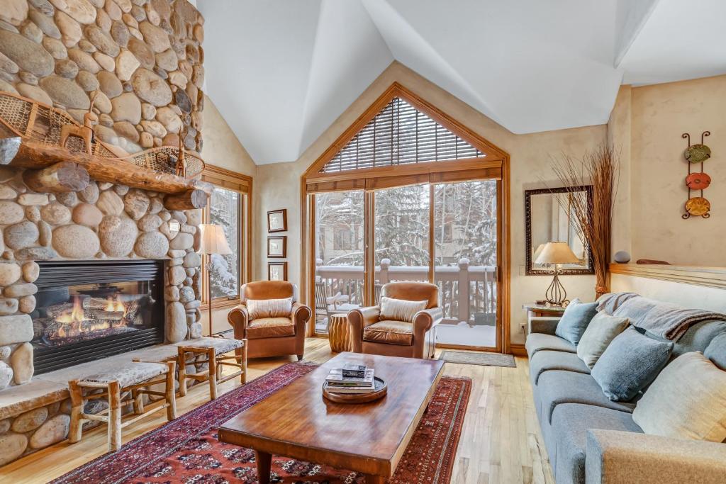 a living room with a large stone fireplace at Cozy Mountain 4-Bedroom Retreat in Arrowhead Village townhouse in Edwards